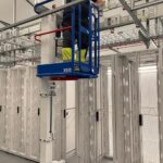 Worker on lift in data center