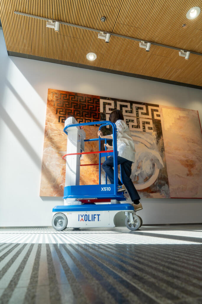 Stepping onto the X510 beside a large wall artwork
