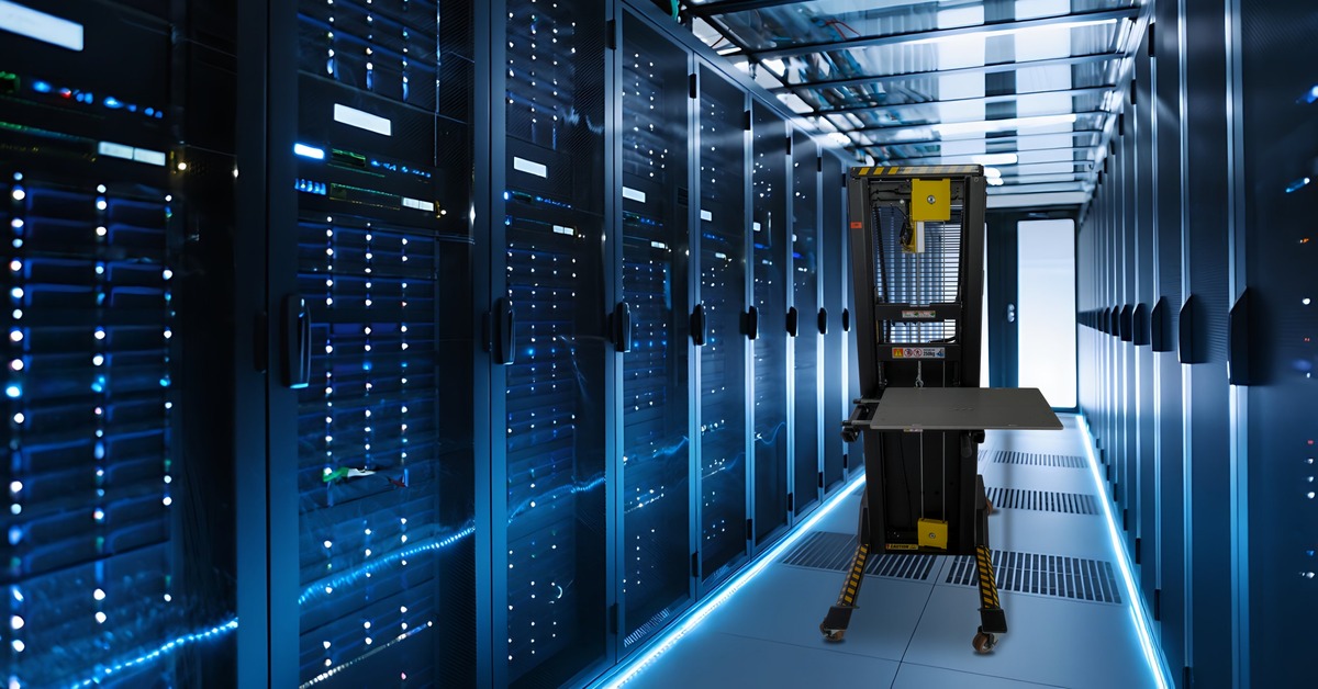 DataLift E Pro server lift with its platform partly raised, in a blue-lit data centre aisle between tall rows of server racks.