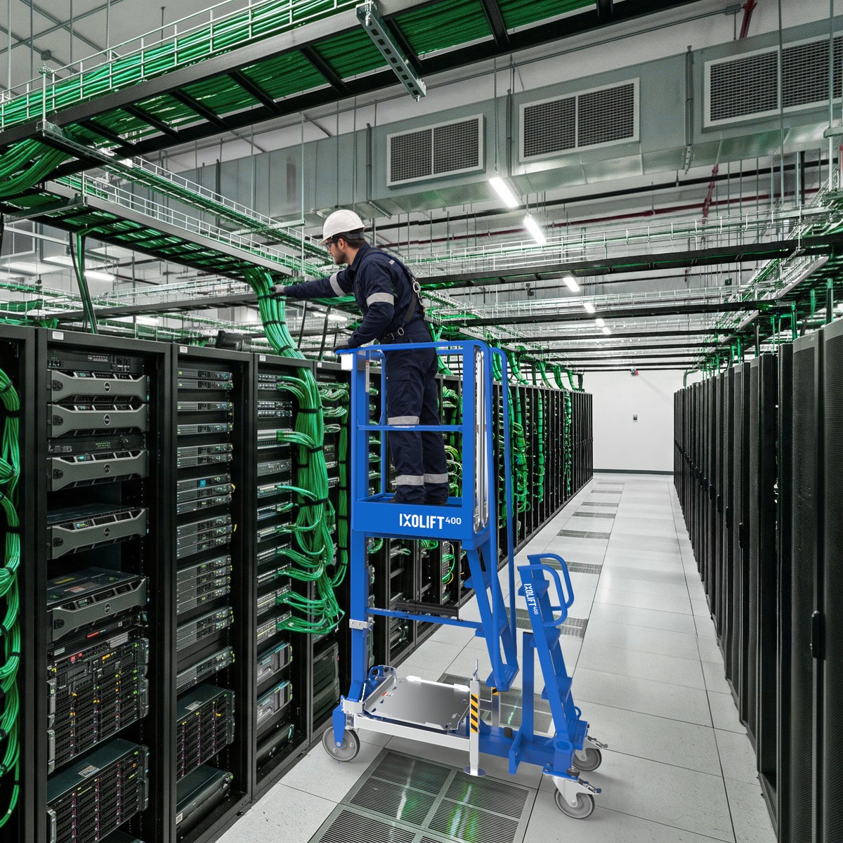 Technician on a blue IXOLIFT X400 work platform in a data centre aisle, working on cables above the racks.